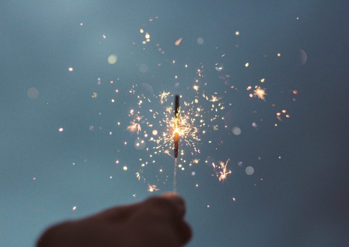 person holding lighted sparklers