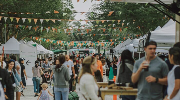 a crowd of people walking around a market