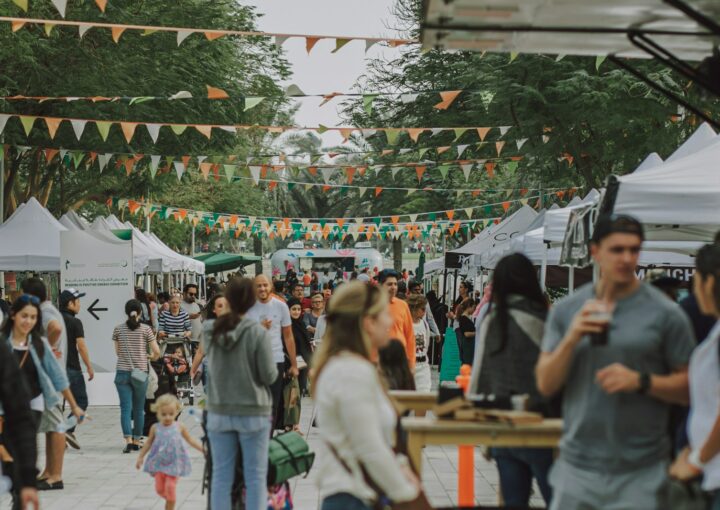 a crowd of people walking around a market